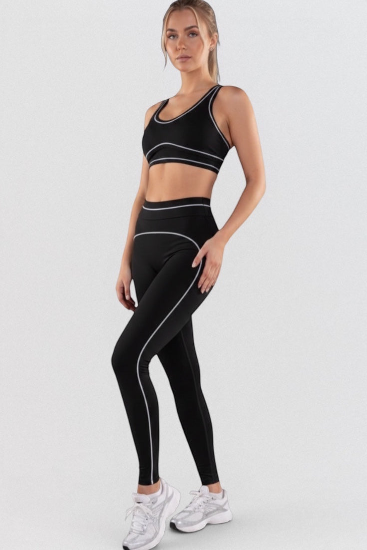 LUPPO black high-waisted leggings with white contour piping detail, made from a nylon/elastane blend.